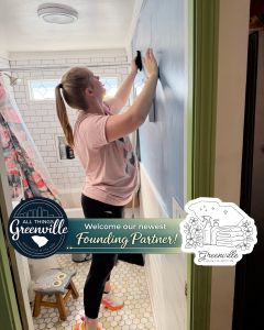A woman cleans a blue bathroom wall; text reads "Welcome our newest Founding Partner! Greenville Clean Collective.