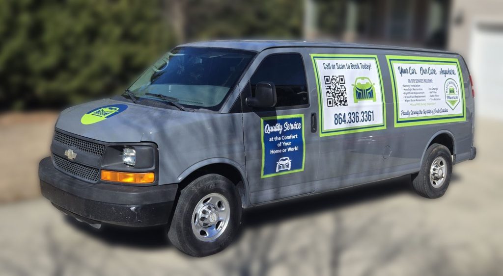 Gray service van with green and blue signage, displaying a phone number, QR code, and booking information.