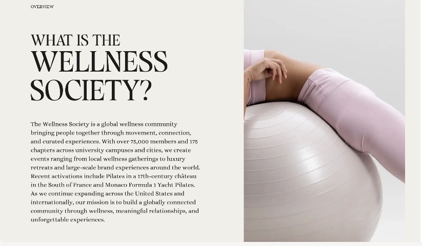 Person in pink workout clothes rests on a large exercise ball next to text about The Wellness Society community.
