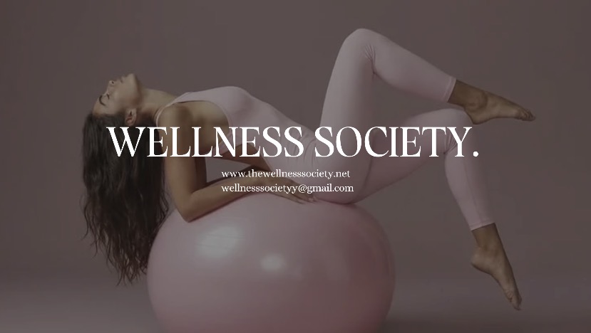Woman in pink workout clothes lying on a pink exercise ball with “WELLNESS SOCIETY.” text overlay.